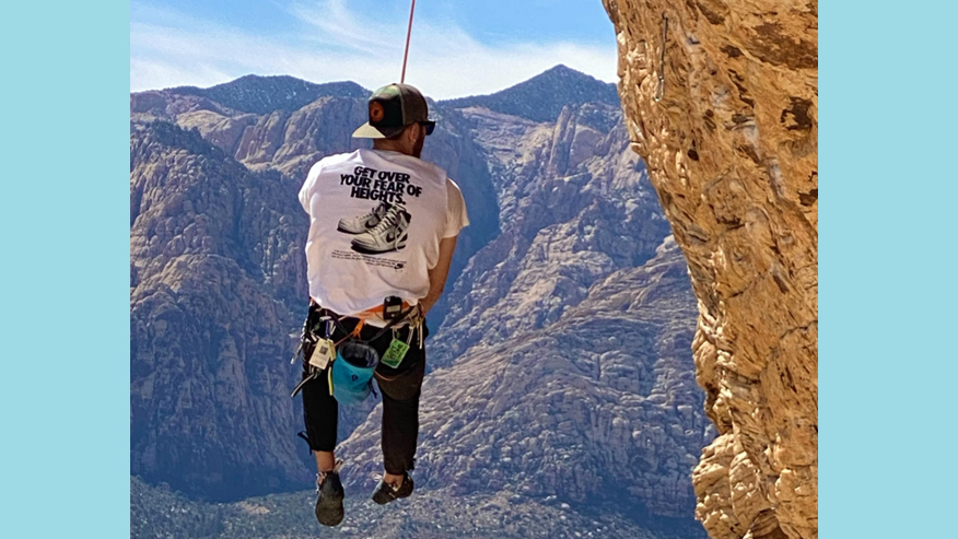 Cam Kellar hanging from a rock while climbing near Las Vegas, Nevada. 