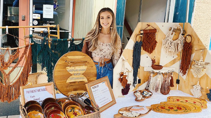 Kimberly Morris posing at a both with her handmade goods. 