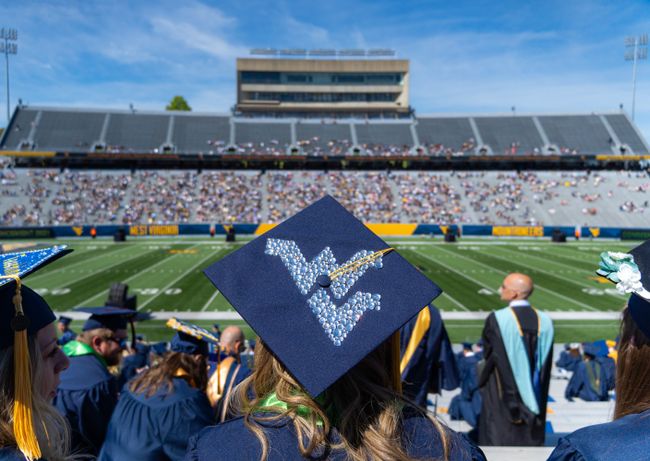 Graduation cap with the Flying WV and Milan Piskar Stadium in the background
