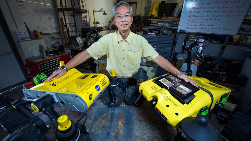 A photo of Powsiri Klinkhachorn with the two WVU Mars Rover Robots