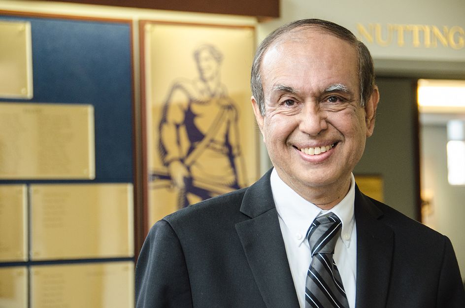 Portrait of Rakesh Gupta with picture of WVU Mountaineer behind him.