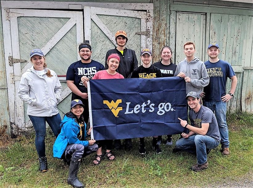 WVUEWB holding a WVU flag while volunteering in McComas West Virginia 