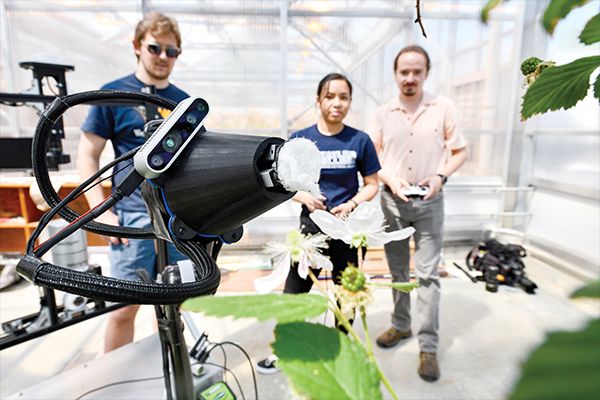 Researchers with pollinator robots