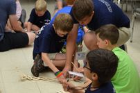 A photo of campers building things out of popsicle sticks.
