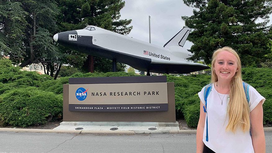 Eleanor Kearney standing in front of the NASA Research Park Statue