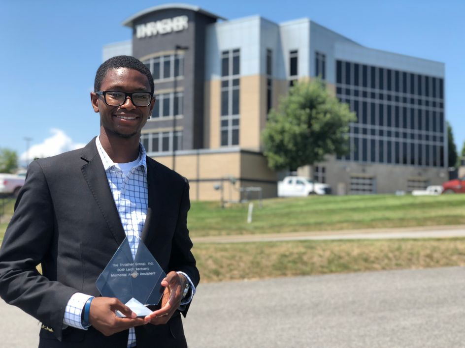 Torey Wright with his award in front of The Thrasher Group building