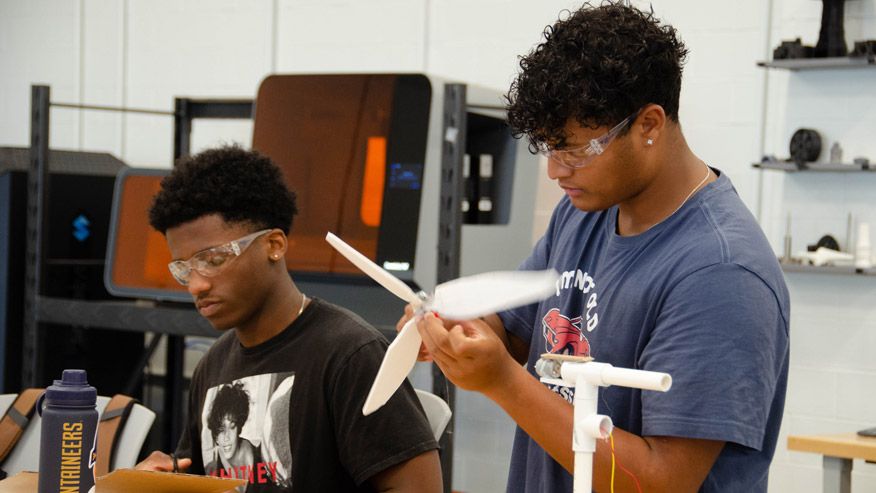 Students of color working on a propeller