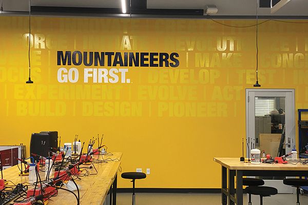 A wall in the Lane Innovation Hub reading "Mountaineers go first."