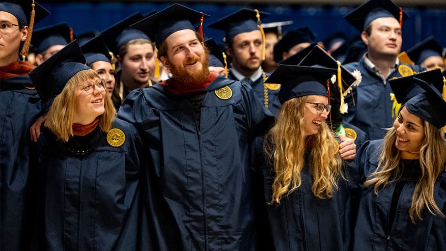 WVU students in cap and gowns at graduation. 