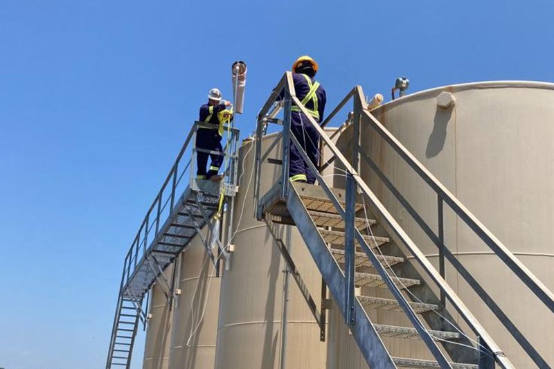  researchers attach instruments to water storage tanks at a natural gas production site