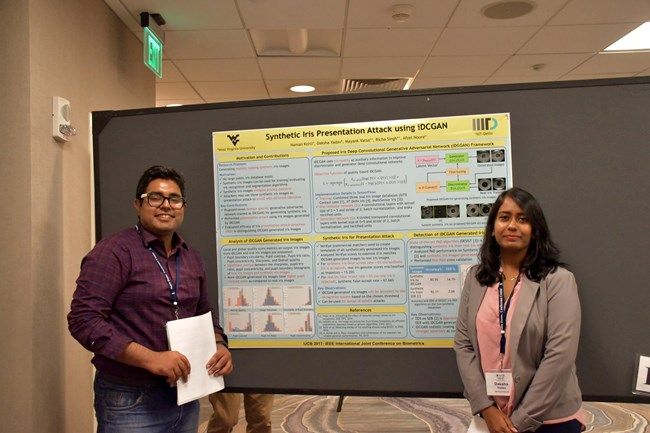 Doctoral students Kohli and Yadav stand in front of their poster that won them a Best Poster Award at the International Joint Conference on Biometrics