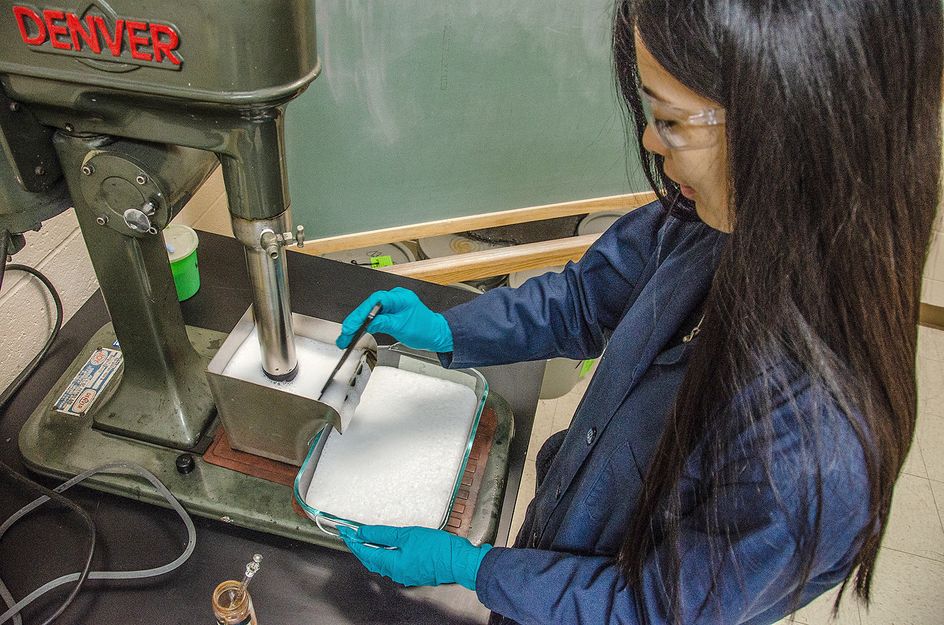 Portrait of Qingqing Huang performing research with coal water.