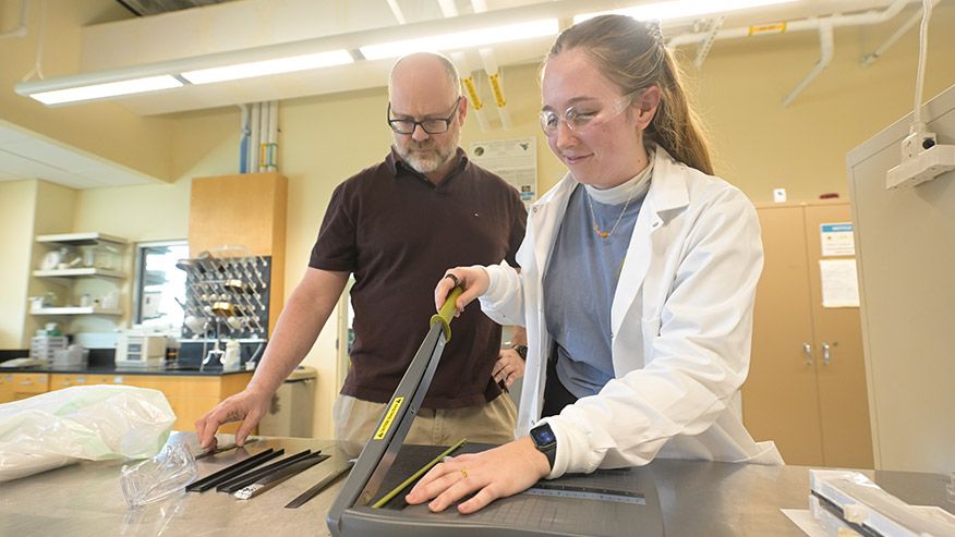 Mechanical, materials and aerospace engineering department professor assists a student in the lab