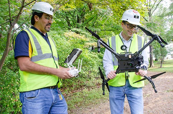 WVU researchers Guilherme Pereira and Ihsan Berk Tulu examine a drone