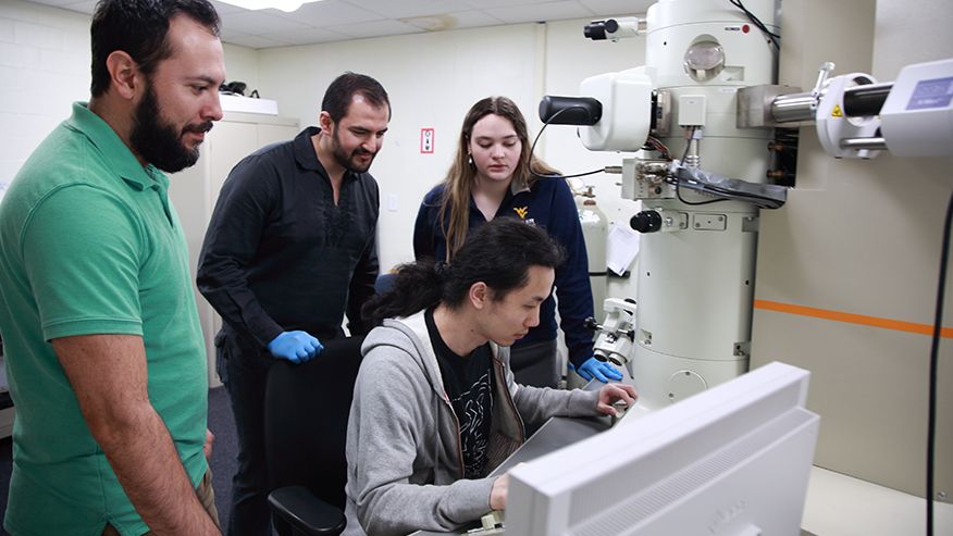 WVU researchers Sergio Andres Paredes Navia, Cesar Octavio Romo de la Cruz, Liang Liang and Ellena Gemmen use an electron microscope.
