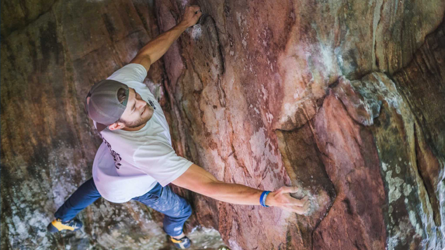 Cam Kellar climbing on a rock formation. 