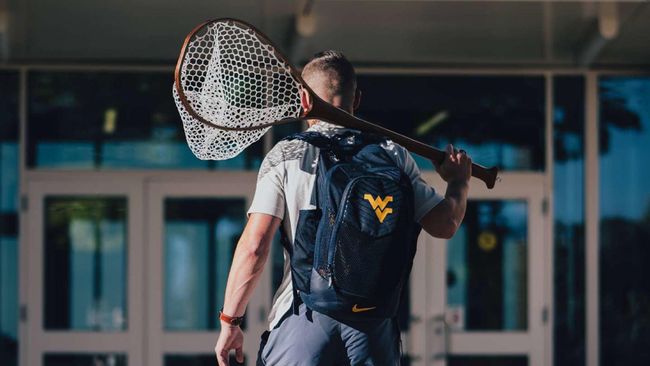 Student with a wvu bookbag holding a fishing net. 