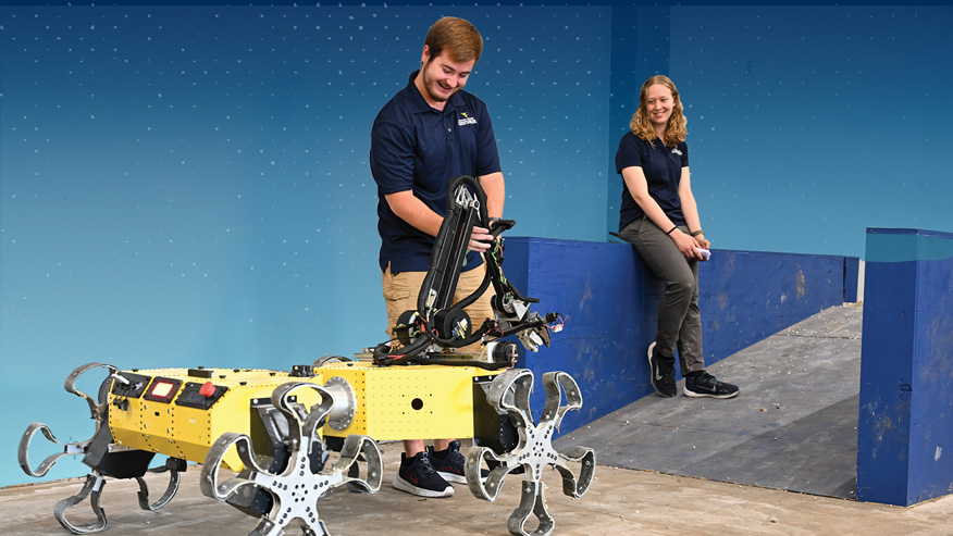 Two students and a yellow robot