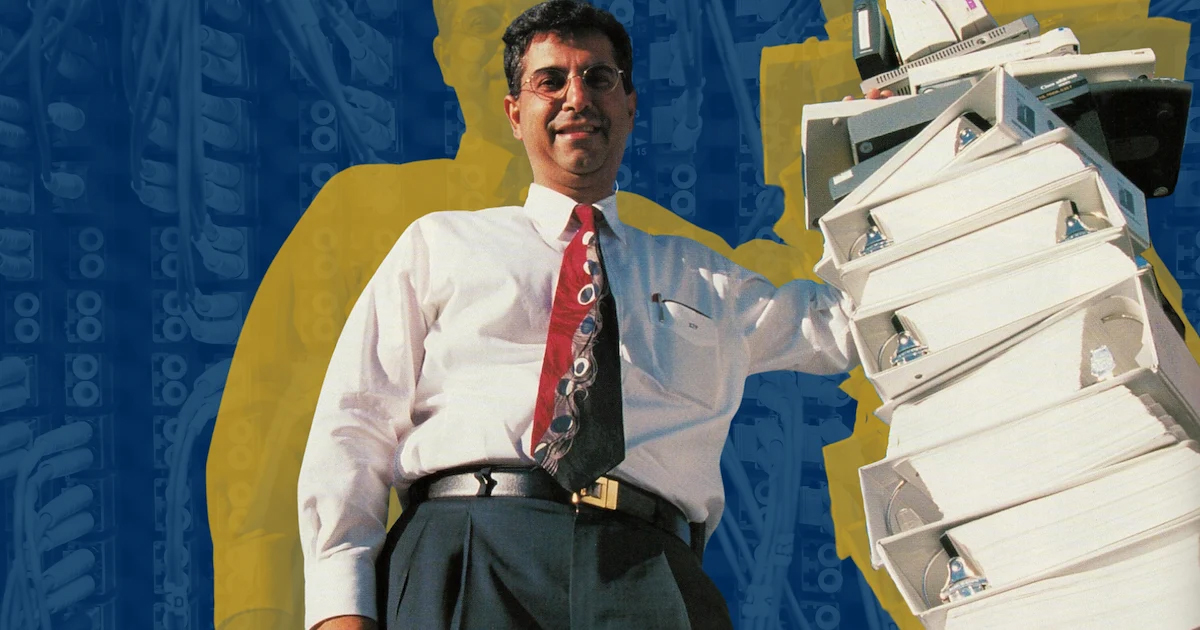 Rouzbeh Yassini next to a stack of white folders.