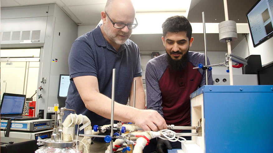 Professor of Mechanical, Materials and Aerospace Engineering Edward Sabolsky works with materials science doctoral candidate Saad Waseem to prepare a solid-oxide electrolysis cell manufacturing test. (WVU Photo/Paige Nesbit)