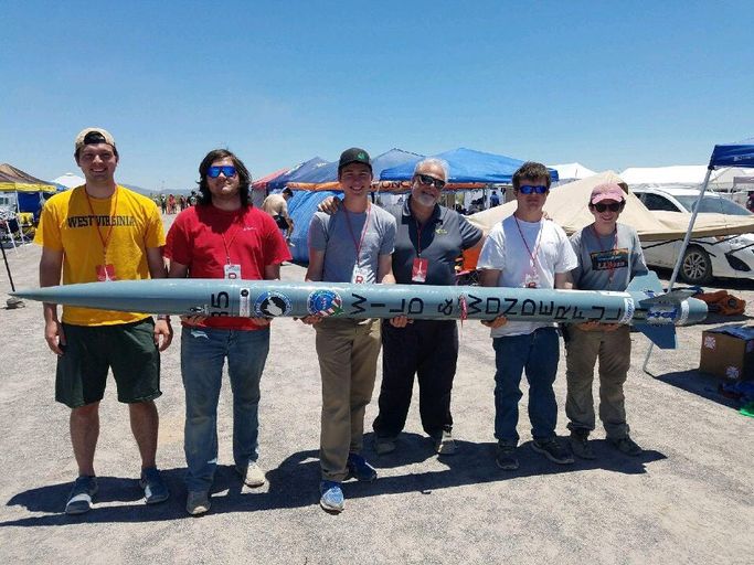 WVU engineering students holding their rocket with Dean Gene Cilento at the Spaceport America Cup. 