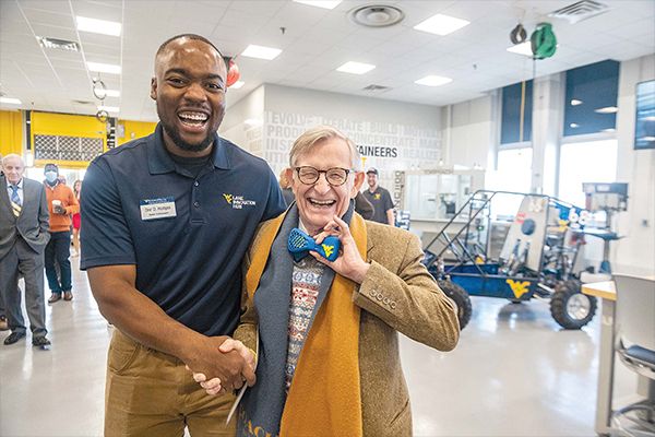 Dre Hodges shaking the hand of E. Gordon Gee.