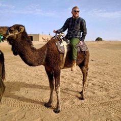 A photo of Tyler Hartman on a camel.