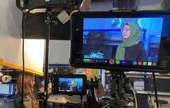 Amina Irfan's interview shown on a video monitor.