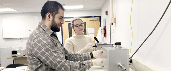 Graduate students in Song's research lab perform a measurement of electrical properties.