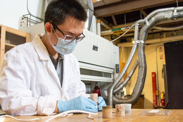 Assistant Professor Wenyuan Li assembles a solid oxide electrolysis cell, a device that uses electricity to split water into hydrogen and oxygen to generate green, high purity hydrogen, to the ceramic housing
